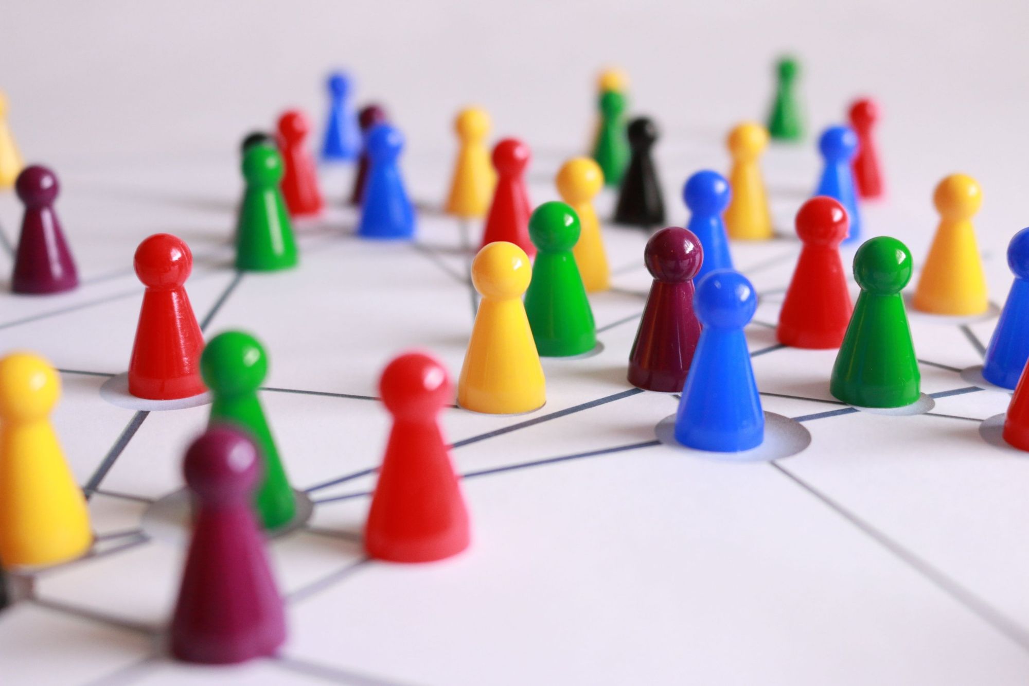 Colored game pieces connected across a network, representing market segments
