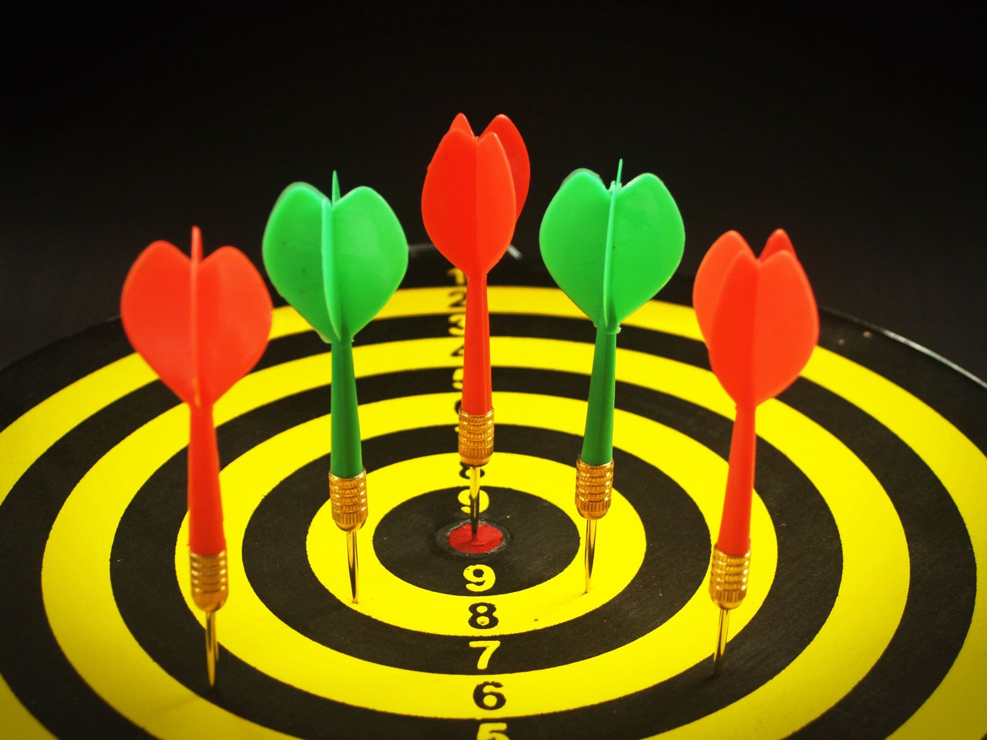 Darts clustered around the bullseye of a target